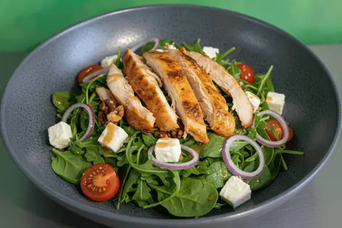 Mediterranean Chicken Salad: roast chicken, rocket, spinach, tomato, onion, goat cheese, nuts and citrus dressing